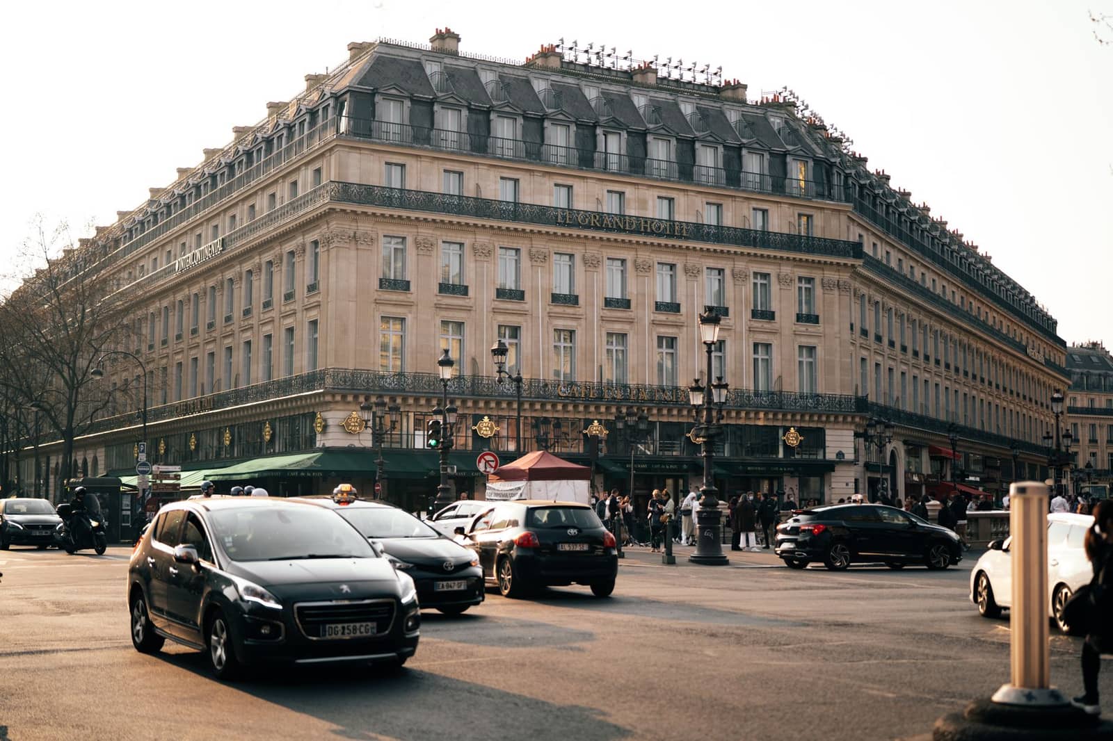 Voiture de luxe berline noire garée devant un hôtel élégant au crépuscule
